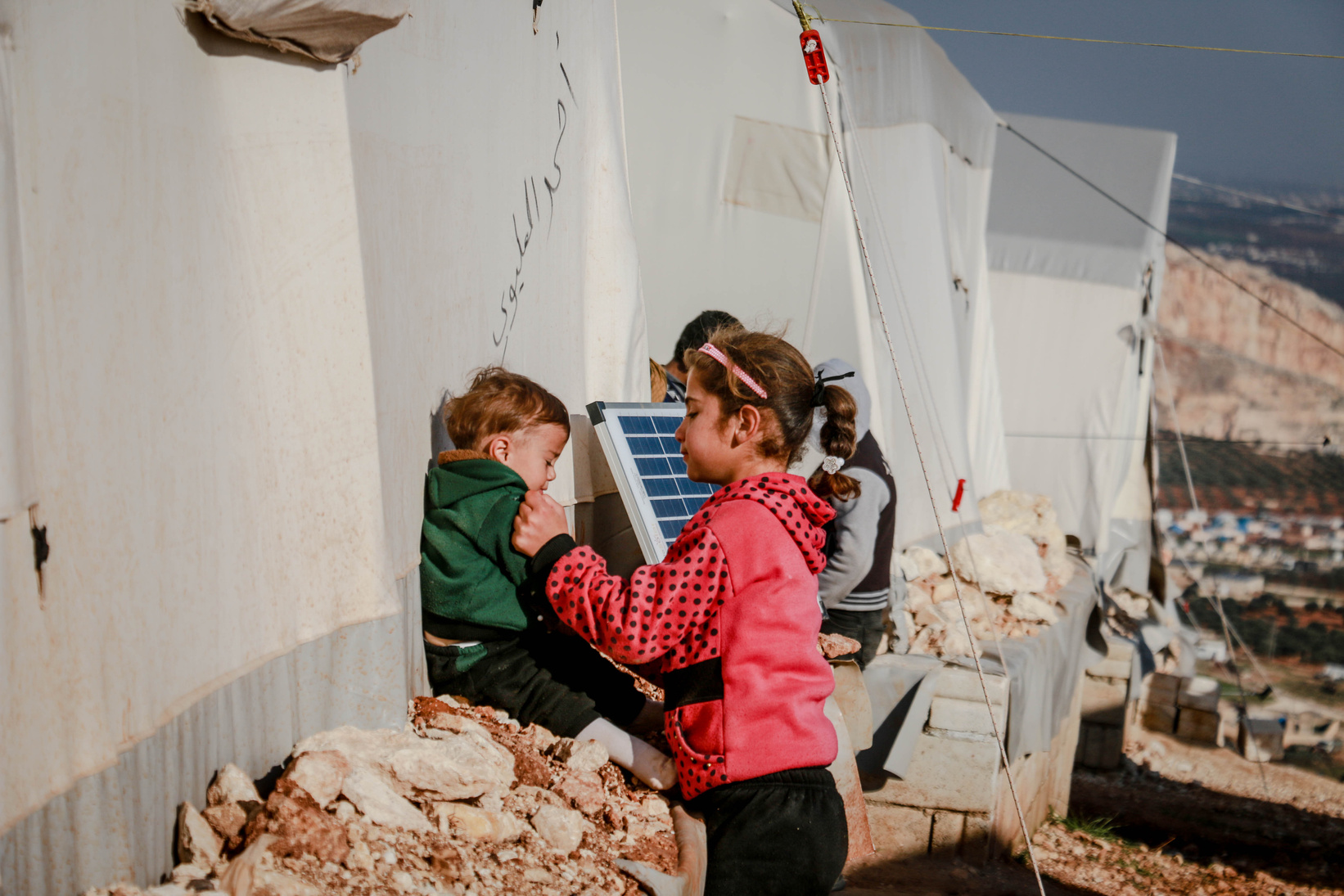 Ethnic children outside refugee tents