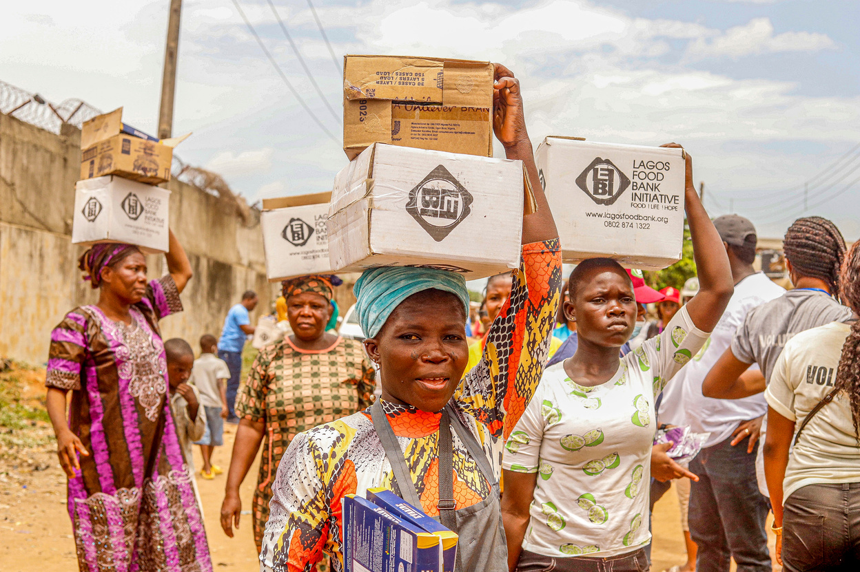 A Group of Women Carrying Cardboard Boxes on Their Heads 